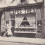 Devanture historique Cafés Thés Verlet, façade années 1920 avec vitrines ornées de plantes et rideaux à Saint Honoré